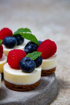 small desserts with fresh berries and cream on a stone platter for display in the kitchen