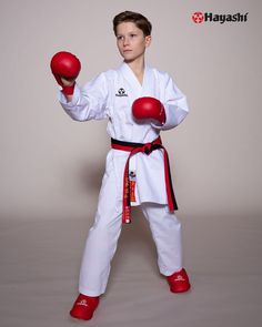 a young boy wearing red boxing gloves and holding two red balls in one hand while standing next to each other