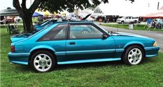 a blue car parked on top of a lush green field