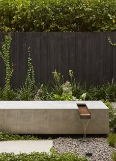 a concrete bench sitting in the middle of a garden