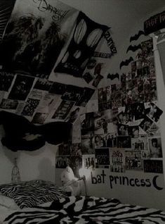 black and white photograph of a bed with lots of pictures on the wall