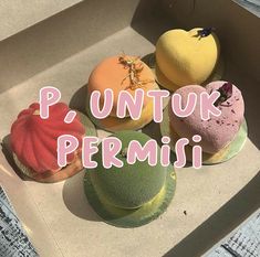 four different colored donuts in a box with the words p, untuk permini