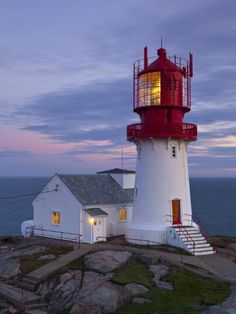 a red and white lighthouse sitting on top of a rock