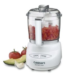 a pink blender sitting on top of a counter next to apples and cucumbers