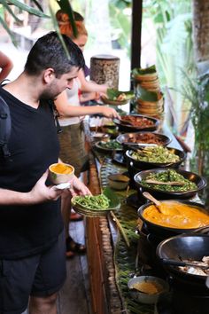 a man standing in front of a buffet filled with lots of different types of food