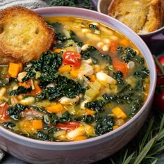 a bowl of vegetable soup with bread on the side