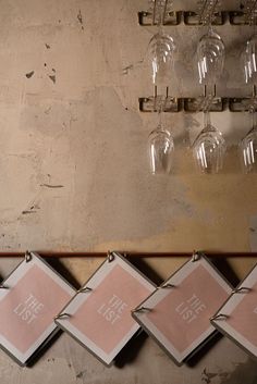 five wine glasses are hanging on the wall next to some pink napkins that have been placed in front of them