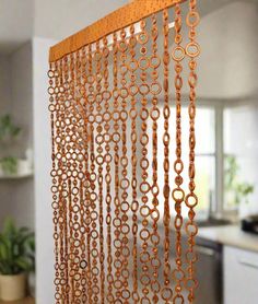 a curtain made out of circles and chains hanging from the side of a kitchen counter