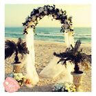 an outdoor wedding setup on the beach with flowers and palm trees in front of it