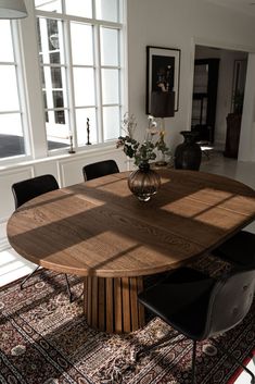 a large wooden table sitting on top of a rug