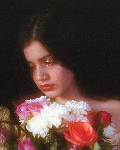 a woman holding a bouquet of flowers in her hands