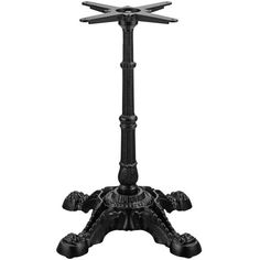 a black metal table with two crosses on it's legs and an ornately carved base