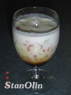 a glass filled with liquid sitting on top of a table