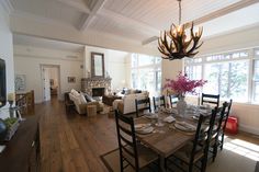 the dining room table is set with place settings for six people and has a chandelier hanging from the ceiling