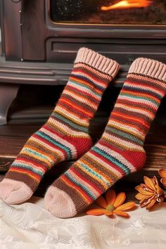 two feet in striped socks next to an open fire place with flowers on the floor