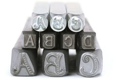 some type of metal letter blocks with the letters abc and j on them, all in different sizes