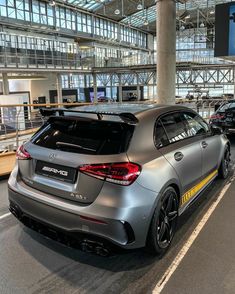 the rear end of a silver car parked in an airport