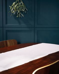 a wooden table with white cloth on it in front of a blue wall and wood paneling