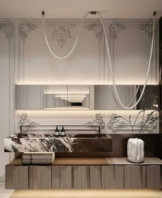 an elegant bathroom with marble counter tops and white walls, along with large mirrors on the wall