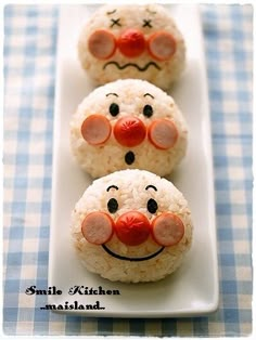 three rice krispy kreme snowmen on a white plate with blue checkered tablecloth