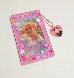 a pink photo frame with a heart shaped keychain attached to it