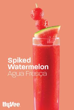 a red drink in a tall glass with a slice of watermelon on top