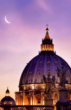 the dome of a building with statues on it and a crescent moon in the background