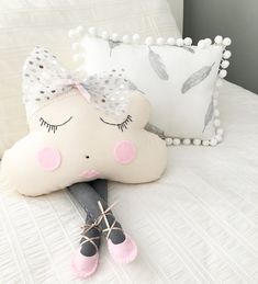 a white pillow with a pink bow on top of it next to a pair of shoes