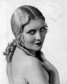 an old black and white photo of a woman with braids on her head, looking to the side