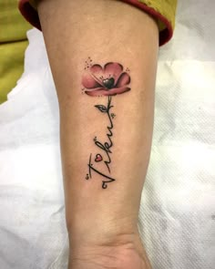 a woman's arm with a flower and the word love written in cursive writing