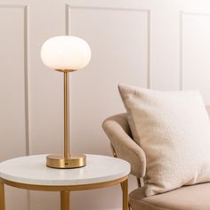 a living room with a couch, chair and lamp on it's side table