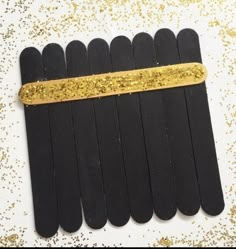 black popsicle sticks with gold glitter on them