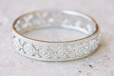 a close up of a wedding ring on a stone surface with diamonds in the middle