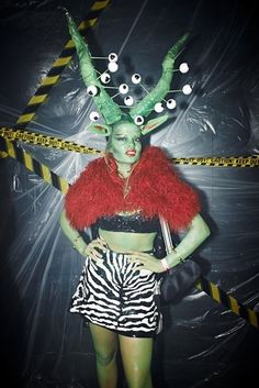 a woman dressed in costume with horns and eyeballs on her head