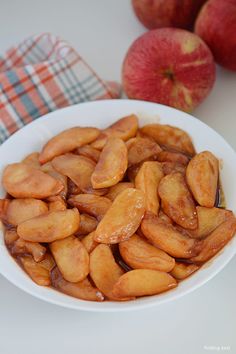 a white bowl filled with sliced apples on top of a table