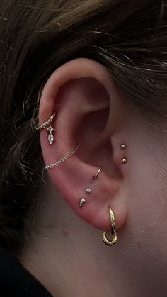 a close up of a person's ear with three different piercings on it