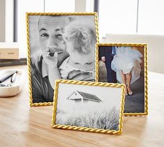 three different frames sitting on top of a wooden table