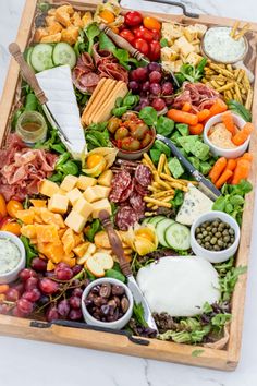 a platter filled with assorted meats, cheese and vegtables