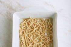 some noodles in a white bowl on a table