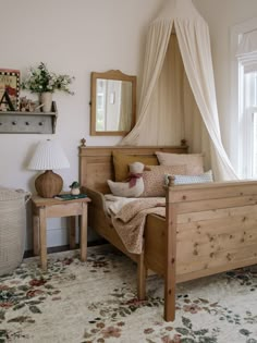 a bedroom with a canopy bed and two tables in front of the window, along with a rug on the floor