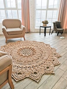 a living room area with two chairs and a rug on the floor in front of large windows