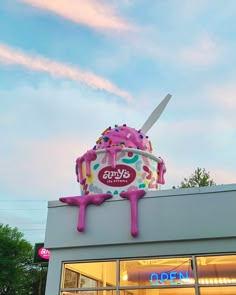 an ice cream shop with pink frosting and sprinkles on the roof