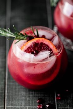 two glasses filled with blood orange punch and garnished with rosemary