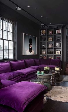 a living room filled with purple couches and windows