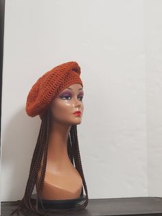 a mannequin head wearing an orange knitted hat