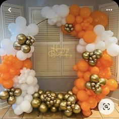 an orange, white and gold balloon arch