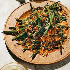 a wooden plate topped with green beans and rice