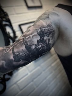 a man with a black and grey tattoo on his arm