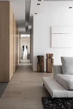 a modern living room with white walls and wood flooring on the side, along with an area rug