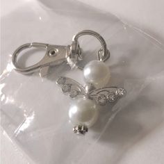 a pair of scissors with pearls attached to them on a clear plastic bag that is sitting on a table